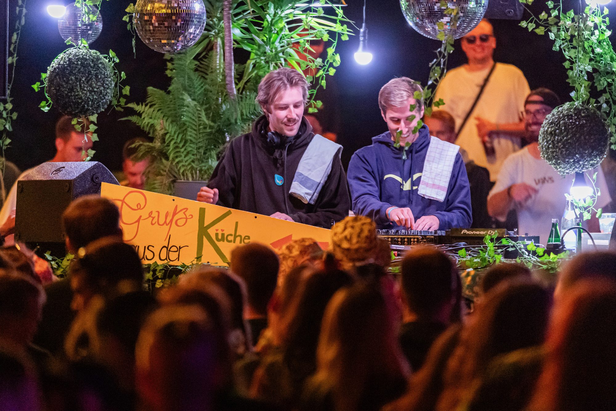 Zwei DJs vom Kollektiv Geschmack hinter den Decks mit &bdquo;Gruß aus der Küche&ldquo;-Schild